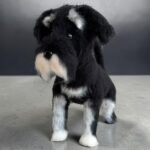 Szydełkowany piesek rasy sznaucer, czarno-biały, z charakterystyczną bródką, wykonany techniką amigurumi.
