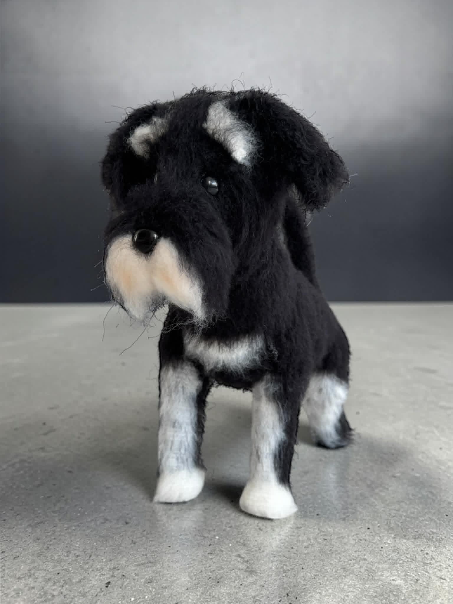 Szydełkowany piesek rasy sznaucer, czarno-biały, z charakterystyczną bródką, wykonany techniką amigurumi.